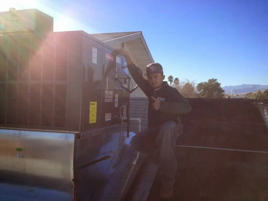 HVAC technician performing Boiler Repair on a rooftop unit in Dallas